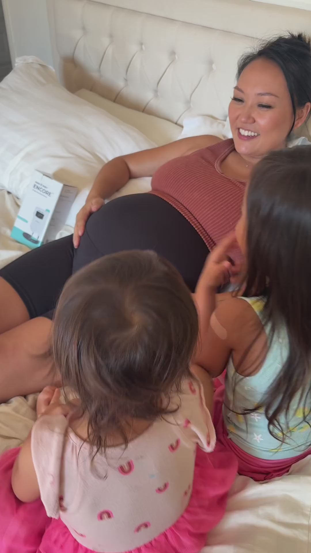 Pregnant woman and children using Aura Baby Encore Fetal Doppler